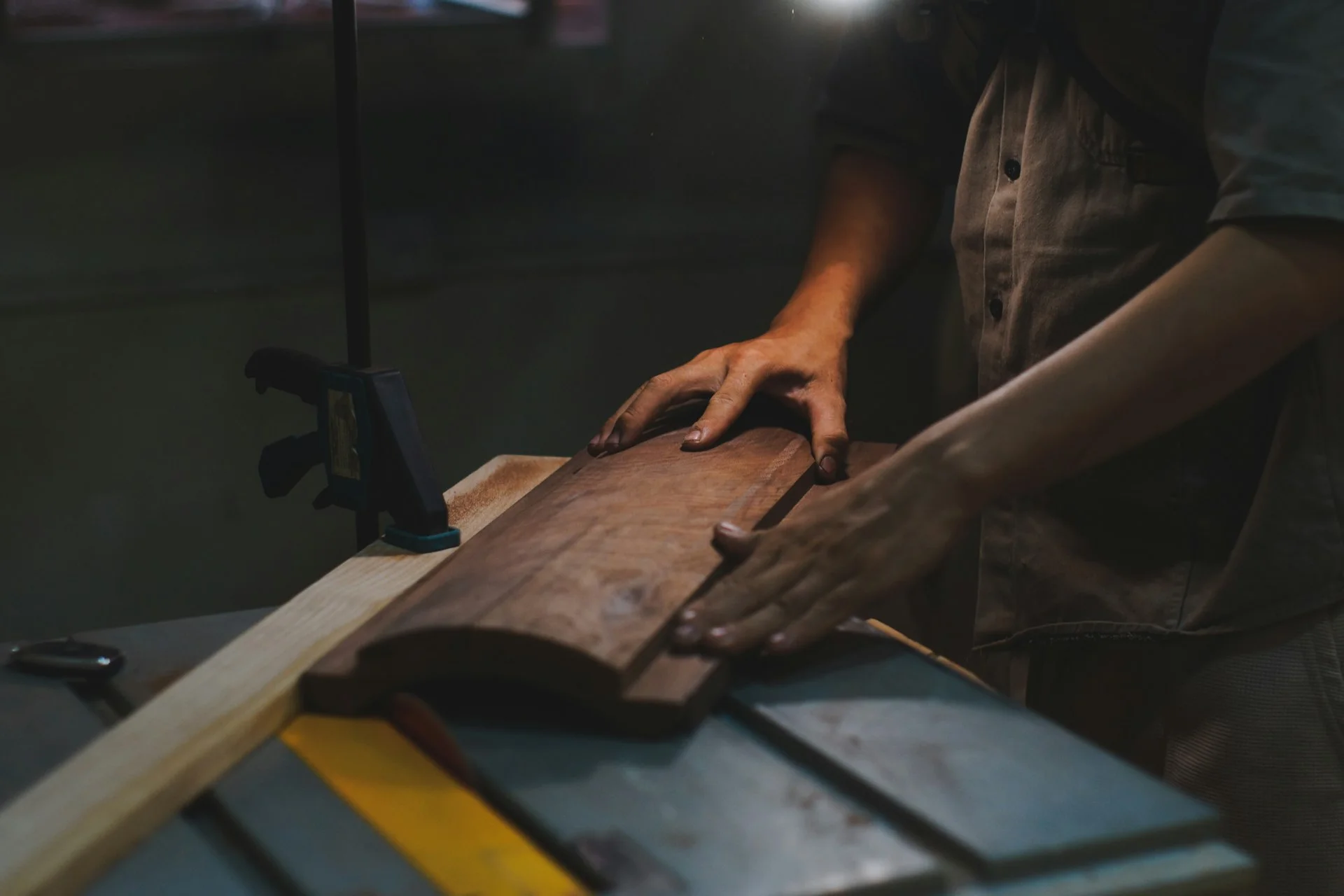 A craftsman shaping a board on a table saw